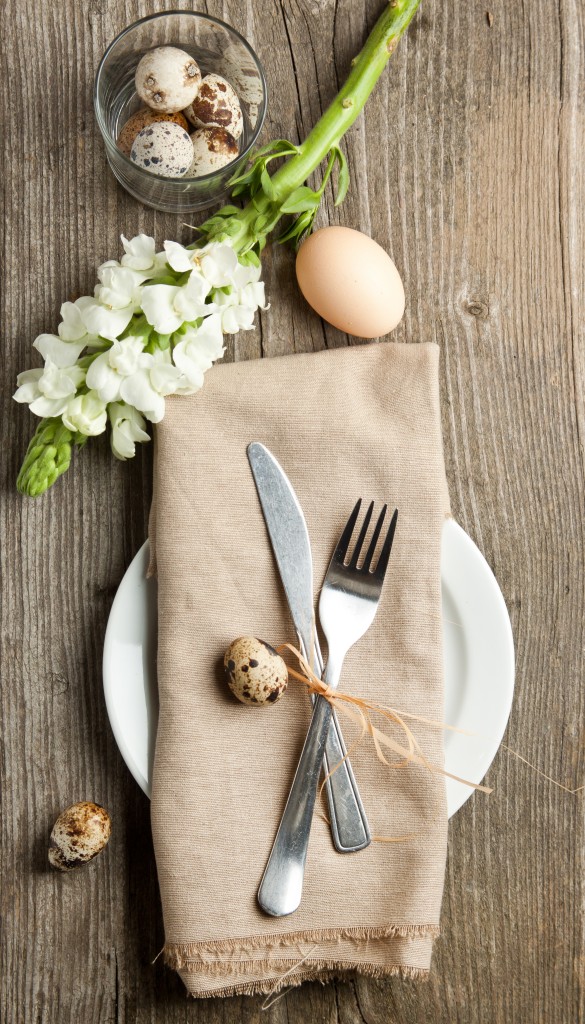 Easter table setting with flowers and eggs on old wooden table
