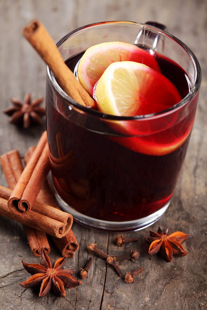 Mulled wine and spices on wooden background
